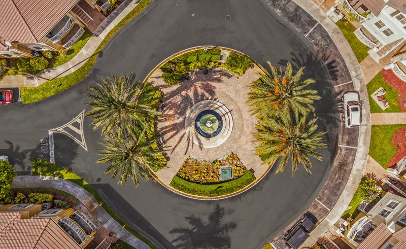 Aerial view of a round-about with a fountain and palm trees