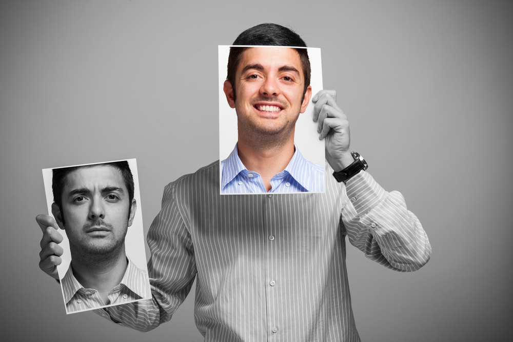 A Guy Holding Two Pictures Demonstrating Happy And Worried